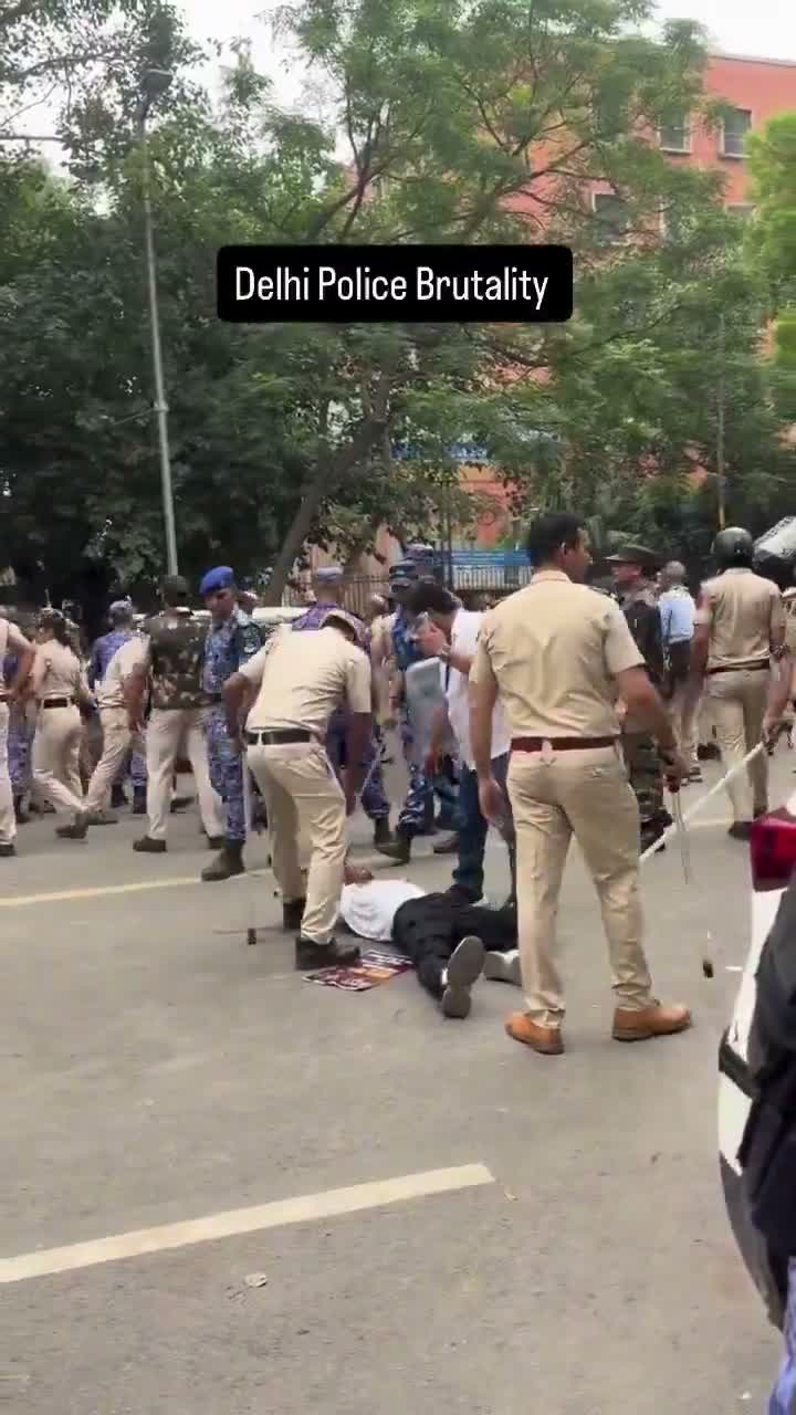 Police detain a woman amid a crowd of security personnel