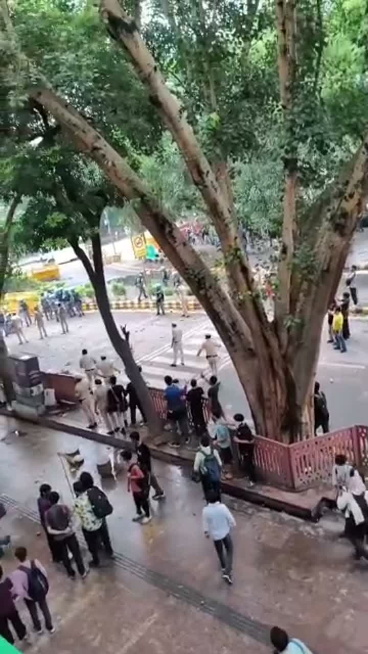 Riot police advance along a street, filmed from above