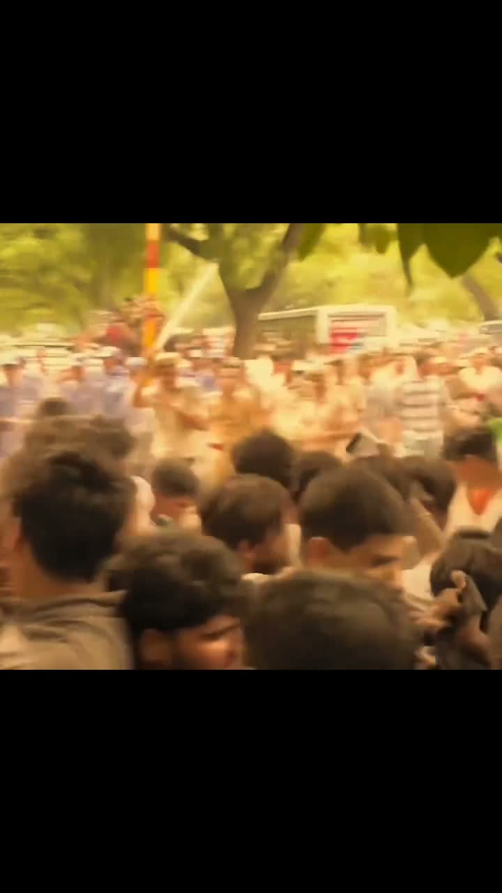 Woman climbs onto a car hood amid a crowd confronting police