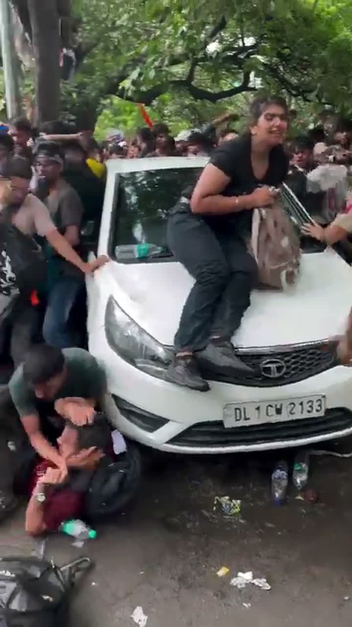 Police officer strikes a person lying on the ground with a stick