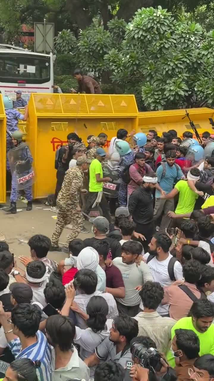 Riot police strike overturned barricades amid a dense crowd